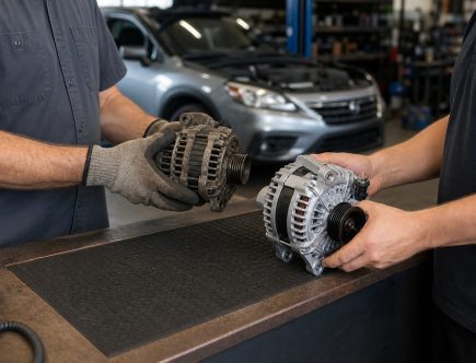 Mechanic exchanges a used alternator core for a clean remanufactured alternator at an automotive parts counter